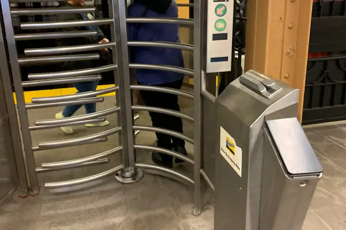 A subway high-entrance, high-exit turnstile gets ready for an OMNY reader.